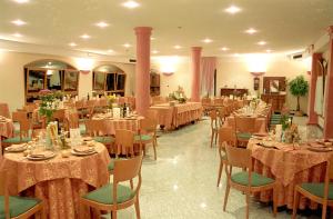 a banquet hall with tables and chairs in a room at Hotel Boomerang - Check-in & Meals in front at hotel Sporting in Tabiano