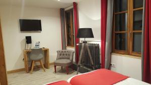 a bedroom with a bed and a chair and a television at Hotel Du Clocher in Chamonix
