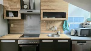 eine kleine Küche mit Spüle und Mikrowelle in der Unterkunft Loft Timonova, Košice - Old Town in Košice