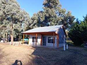 a small shed with a tin roof in a park at Cabañas Hamdan villa residencial laguna brava in Balcarce