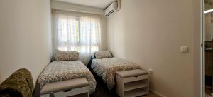 a small room with two beds and a window at Amazing Oceanfront 2br in Oropesa del Mar