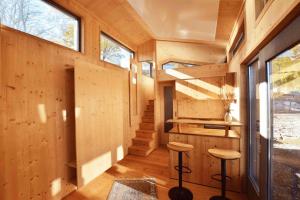 a tiny house with stairs and stools in the hallway at SEINZ Tiny House Natururlaub in Bad Kohlgrub