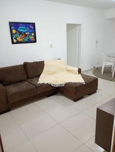 sala de estar con sofá y manta en Apartamento Quadra Mar Meia Praia, en Itapema
