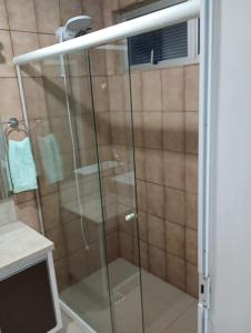 una ducha con puerta de cristal en un baño en Apartamento Quadra Mar Meia Praia, en Itapema