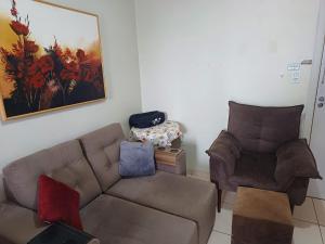 un salon avec un canapé et une chaise dans l'établissement Apart próximo a Unimed, Catedral e HSA de 2 quartos com 2 Ar, mini-Academia e garagem no Centro-sul, à Santo Ângelo