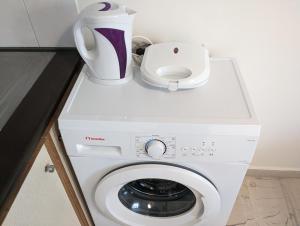 a white washing machine with a blender on top of it at Herakleion center single room in Bendevís