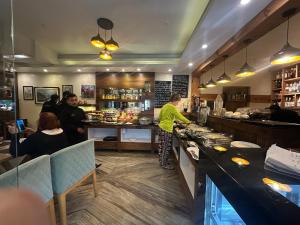 a woman preparing food in a restaurant kitchen at Hotel Middle Path & Spa in Pokhara