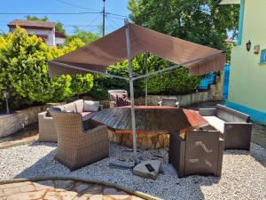 a patio with a table and an umbrella at Casa Elena in Eforie Sud