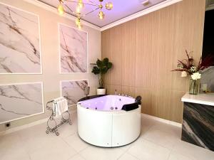 a bath tub in a room with paintings on the wall at Sopot Spa Apartament in Sopot