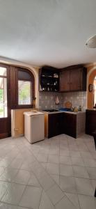 a large kitchen with a white refrigerator and cabinets at La Quiete garden in Canneto +8 photos