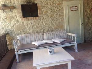 a bench against a stone wall with pillows on it at Agriturismo le Colline in Montescudaio
