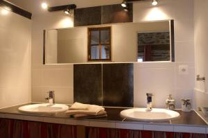a bathroom with two sinks and a mirror at Maison d'hôtes la Passemarié in Andouque