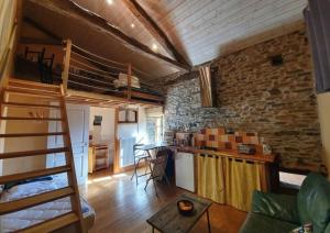 a living room with a loft bed and a kitchen at Maison d'hôtes la Passemarié in Andouque