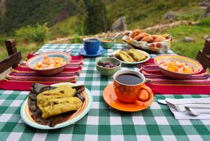 a table with plates of food and a cup of coffee at La Casa de Mario - Gocta in Cocachimba