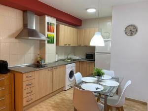 a kitchen with a table and chairs and a sink and a stove at Apartamentos Alcañiz, Santa María, 3 in Alcañiz