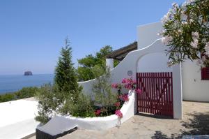 a white house with a gate with flowers at La Sirenetta Park Hotel in Stromboli