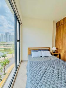 a bedroom with a bed and a large window at 2 phòng ngủ Solari nhìn công viên liền kề Vincom Mega Mall in Long Bình +73 photos