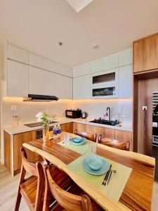a kitchen with a wooden table and some chairs at 2 phòng ngủ Solari nhìn công viên liền kề Vincom Mega Mall in Long Bình