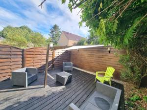 a wooden deck with chairs and a fence at Le Petit Marais in Saint-Martin-lez-Tatinghem