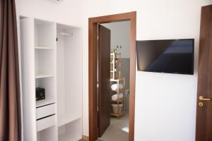 a room with a tv and a door with a closet at Vista Mare 16 in Siracusa
