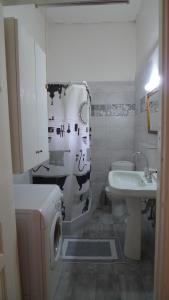 a bathroom with a sink and a toilet and a shower curtain at Philoxenia in Spata +5 photos