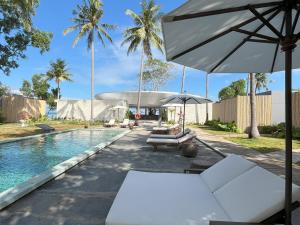 Pulau Tidung-besarにあるNirva Ocean Houseのスイミングプール(椅子、パラソル付)