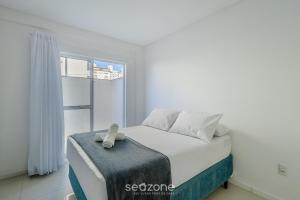 a bedroom with a bed with a teddy bear on it at Apt c/ Churrasq. a 600m da Praia GEN0102 in Balneário Camboriú