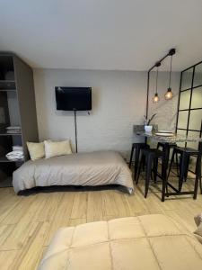 a bedroom with a bed and a table in a room at Monoambiente Espacio super funcional in Guaymallen