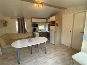 a small kitchen with a white table in a room at Mobil-Home à Camiers dans un camping 3 étoiles in Camiers