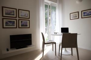 Villa Paola في توري ديل بيناكو: غرفة معيشة مع تلفزيون وطاولة وكراسي