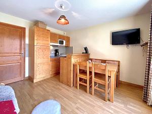 a kitchen and dining room with a table and a television at VARS aux pieds des pistes Appartement T2 4 personnes Résidence Le Hameau des Rennes 4 étoiles avec piscine et parking privés in Vars