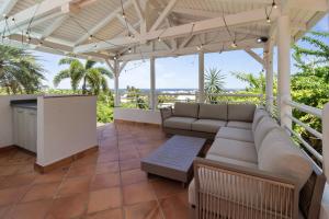 a patio with a couch under a pergola at Villa Maravistah in Saint-François