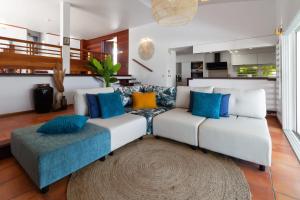 a living room with a white couch and blue pillows at Villa Maravistah in Saint-François