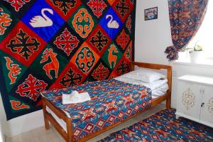a bedroom with a bed and a colorful wall at Kochmon guesthouse in Naryn