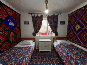 a room with two beds and a window at Kochmon guesthouse in Naryn