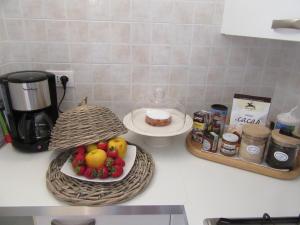 - un comptoir de cuisine avec un bol de fruits sur une assiette dans l'établissement Appartamento Erica, à Arco