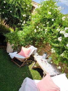 ein Garten mit Stühlen, einem Picknicktisch und Blumen in der Unterkunft Casa-Museo La Casita de Albino in Castillo de Bayuela