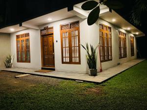 a house with wooden doors and a plant in front at BamBoo Villa in Walliwala East