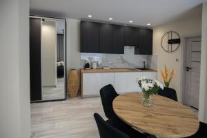 a kitchen and dining room with a wooden table at Aparthouse Kretowiny in Kretowiny