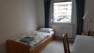 a small bed in a room with a window at Wohnung am Hauptmarkt! in Nuremberg