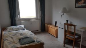 a bedroom with a bed and a desk and a window at Wohnung am Hauptmarkt! in Nuremberg +1 photo