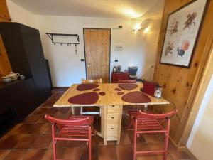 a wooden table with four red chairs around it at Il Nido di Pila , Panoramic Mountain View near Ski Lifts in Pila +37 photos