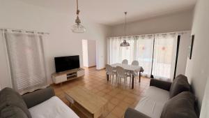 a living room with a table and a television at Anahi Homes Corralejo- Bicacarera 7 in La Oliva