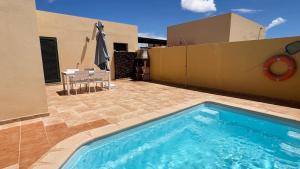 a swimming pool on the side of a house at Anahi Homes Corralejo- Bicacarera 7 in La Oliva