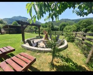 a garden with benches and a gazebo at Vila Passiflora in Dragoslavele