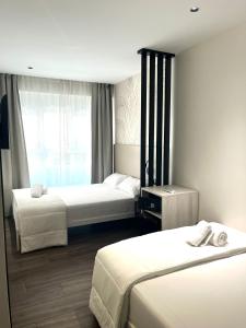 a hotel room with two beds and a window at Rooms&Go in Alicante