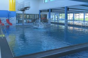 a pool with a fountain in the middle of a building at Hotel Touric in Korbach