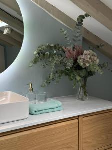 une salle de bain avec un vase de fleurs sur un comptoir dans l'établissement La Casita de Loli, à Madrid