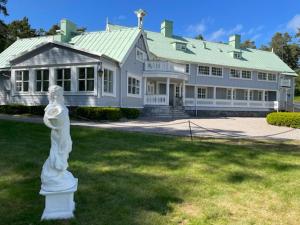a large white house with a statue in front of it at Onsala Herrgård B&B in Kungsbacka