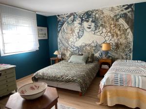 a bedroom with two beds and a mural of a woman at les Marronniers in Vichy